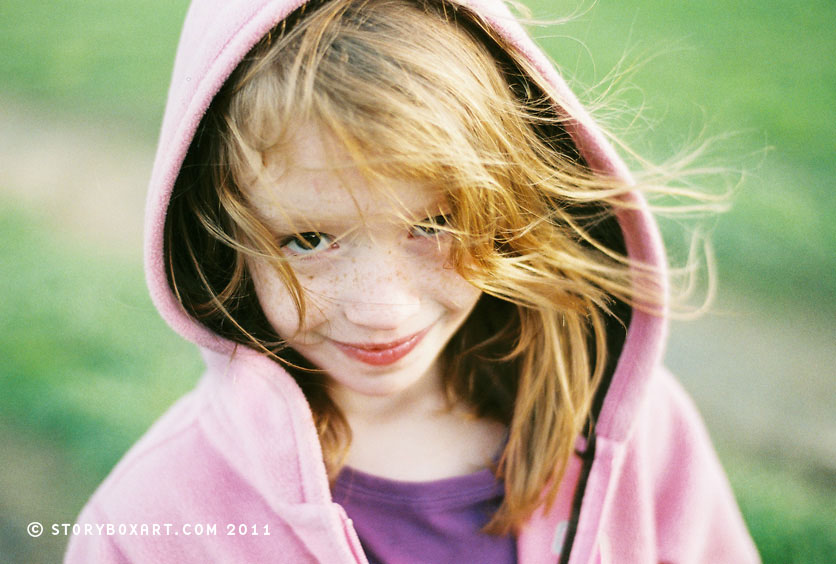 Girl with wind-blown hair in meadow